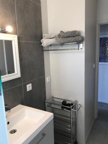 une salle de bain avec un lavabo blanc et un miroir dans l'établissement Appartement Contemporain Pont Vieux, à Carcassonne