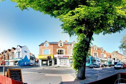 a city street with a tree and buildings at Modern Queens Quarter Townhouse 2 in Belfast