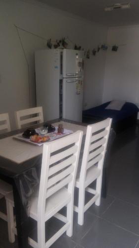 kuchnia ze stołem, krzesłami i lodówką w obiekcie Dpto 2 pers x dia 20mil PESOS w mieście Tres Arroyos