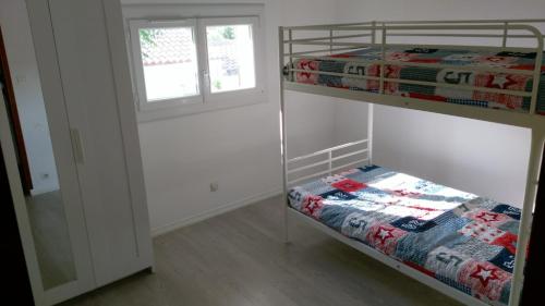 une chambre avec deux lits superposés et une fenêtre dans l'établissement maison avec piscine, à Lézignan-Corbières