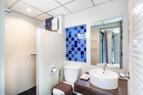 a bathroom with a sink and a toilet and a mirror at Aliz Hotel in Nonthaburi