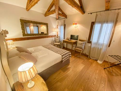 una camera da letto con un letto e una scrivania con un computer di Rigoletto Charm a Venezia