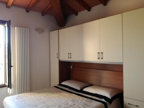 um quarto com uma cama e armários brancos em Finestra Della Val D'Orcia em Contignano