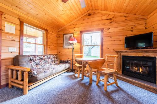 a living room with a couch and a table and a fireplace at Spur of the Moment Ranch in Mountain