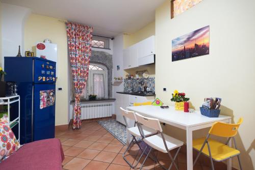 a kitchen with a white table and yellow chairs at Bobbò house in Naples