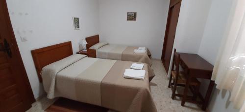 pokój hotelowy z dwoma łóżkami i stołem w obiekcie Convento Madre de Dios de Carmona w mieście Carmona