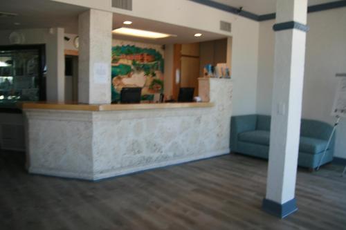 een lobby met een receptiebalie en een blauwe bank bij Chesapeake Beach Resort in Islamorada