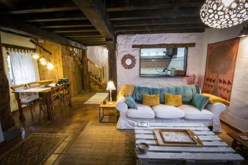 ein Wohnzimmer mit einem Sofa und einem Tisch in der Unterkunft Casa rural La Tenada in Los Narros