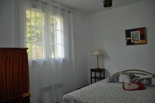 a bedroom with a bed and a window at Le clos de Cantemerle in Saint-Sauveur