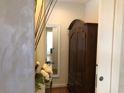 a hallway with a mirror and a wooden cabinet at Hotel Ferro di Cavallo in Pavullo nel Frignano