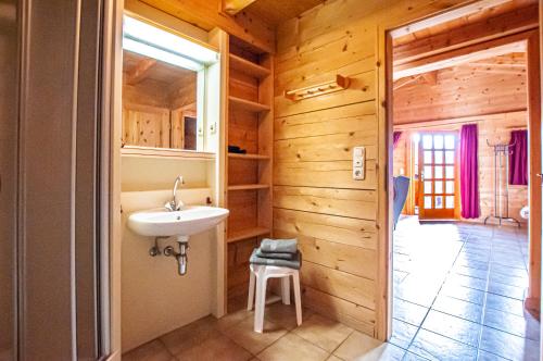 uma casa de banho com um lavatório numa casa de madeira em Ruhige Chalets mit Seeblick in zentraler Lage em Schliersee