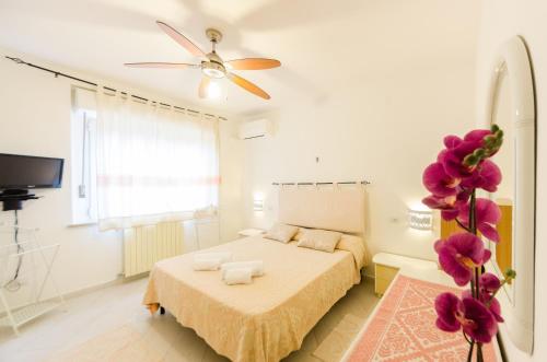 una camera con letto e ventilatore a soffitto di Sardinia-Holiday La casa delle Pavoncelle a La Maddalena