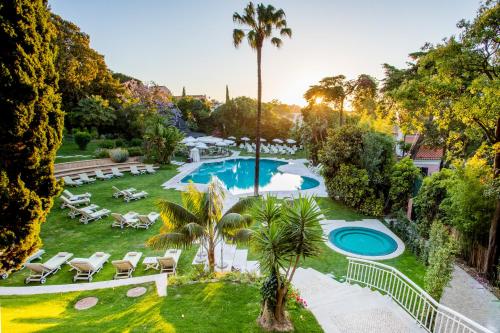
a beach scene with a pool and trees at Olissippo Lapa Palace – The Leading Hotels of the World in Lisbon
