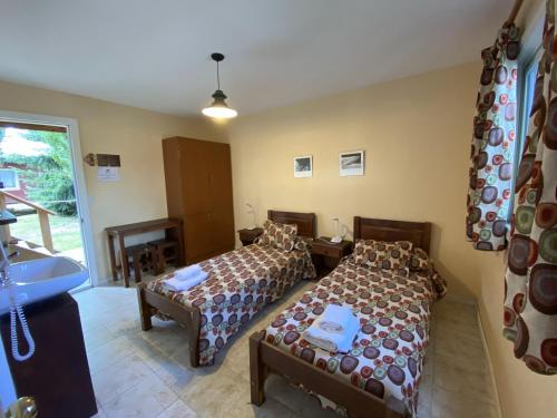 a room with two beds and a sink in it at Hostel Los Pioneros in El Calafate