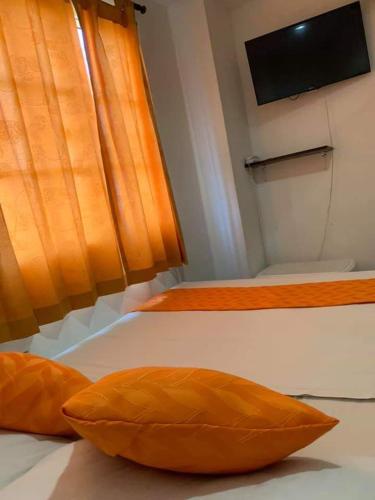 2 almohadas naranjas en una cama en una habitación en Hotel Torres del Parque No1, en Soledad