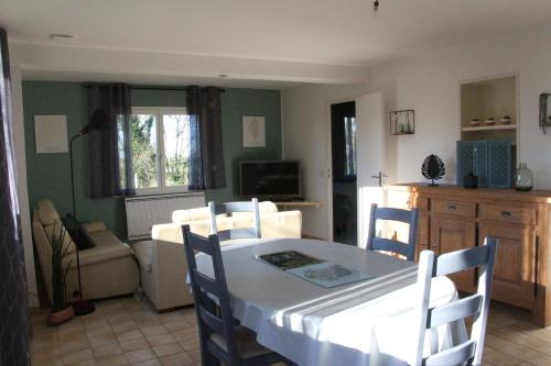 une salle à manger avec une table et des chaises blanches dans l'établissement le p'tit cauxtier, à Senneville-sur-Fécamp