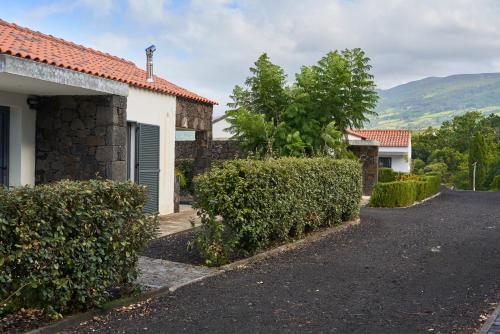 a house with a driveway next to a building at Villa 4 Seasons in São Roque do Pico