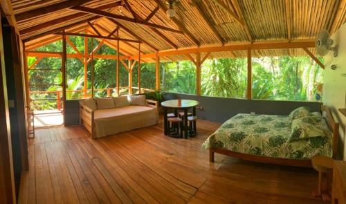 a bedroom with a bed and a couch in a room at Private jungle “Loft del Rio” river access in Uvita