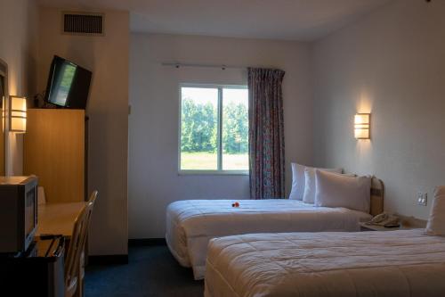Un pat sau paturi într-o cameră la Morgantown Inn & Suites