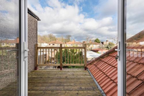 a door leading to a balcony with a wooden deck at The Bluebird - One Bedroom Apartment in Watford in Watford