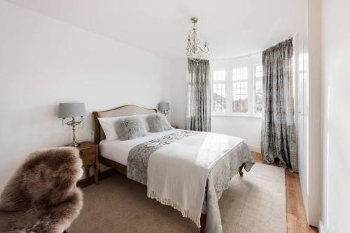 a white bedroom with a bed and a window at The Bluebird - One Bedroom Apartment in Watford in Watford