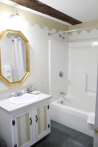 a bathroom with a sink and a tub and a mirror at Old Orchard Beach Inn in Old Orchard Beach