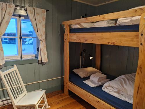 a room with two bunk beds and a chair at Auberge de jeunesse du Domaine à Liguori in Petite-Rivière-Saint-François