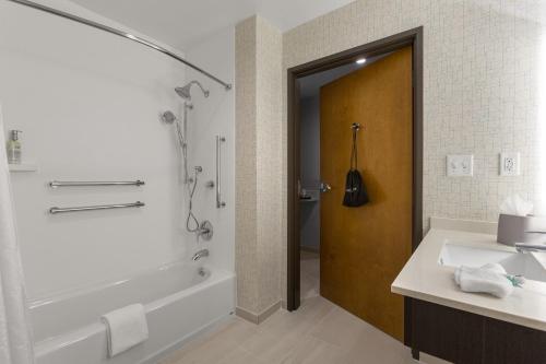 費耶特維爾的住宿－Holiday Inn Express & Suites - Fayetteville South, an IHG Hotel，带浴缸、水槽和淋浴的浴室