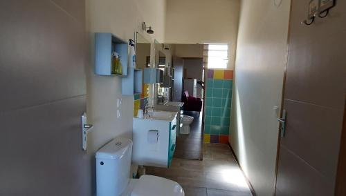 a bathroom with two sinks and a toilet in it at VILLA MARINA Appart Hotes in Bouillante