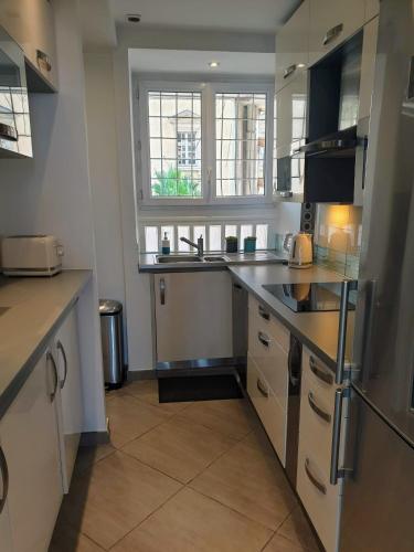 a large kitchen with a sink and a window at Marinca Port View Toulon in Toulon