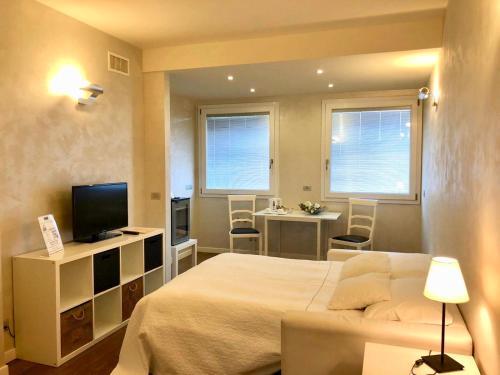 a bedroom with a bed and a television and a table at Hotel Ferro di Cavallo in Pavullo nel Frignano
