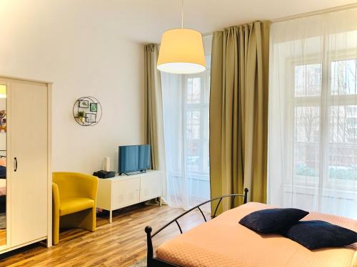a bedroom with a bed and a tv and a window at City-Maisonette in Vienna