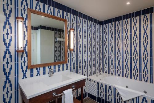 a bathroom with a sink, mirror, and bathtub at El Beso Adults Only At Ocean El Faro - All Inclusive in Punta Cana