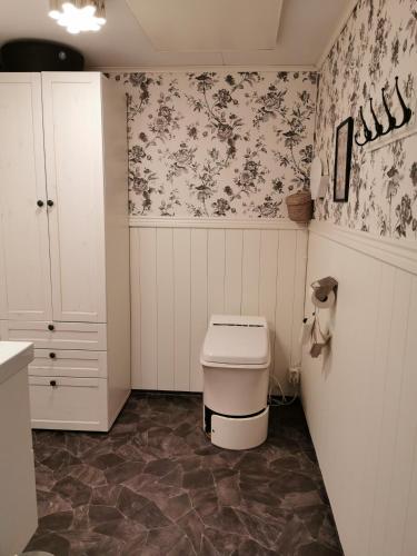 bagno con servizi igienici e carta da parati floreale di Arctic Gourmet Cabin a Kiruna
