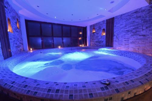 eine große Whirlpool-Badewanne in einem Zimmer mit Beleuchtung in der Unterkunft Casa del Sol Machupicchu in Machu Picchu