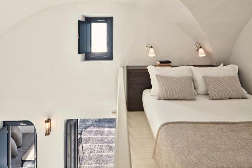 a small bedroom with a bed and a window at Homeric Poems in Fira