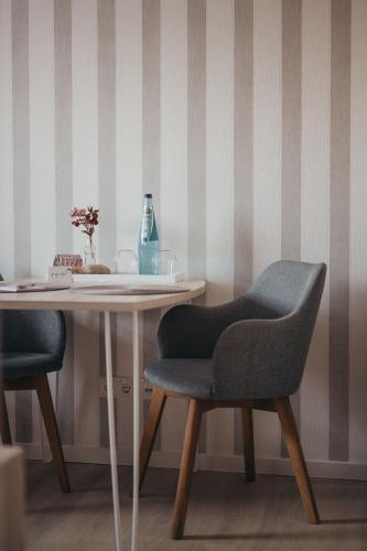 a table with two chairs and a vase on it at Boardinghouse Sorgenfrei in Hagen