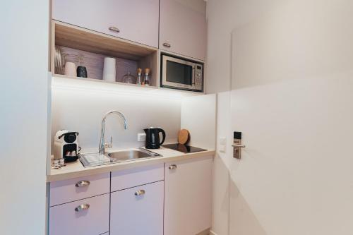 a small kitchen with a sink and a microwave at Boardinghouse Sorgenfrei in Hagen