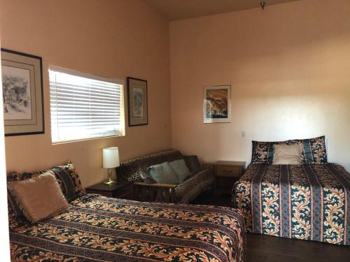 a bedroom with two beds and a couch and a window at 2172 main st in Morro Bay