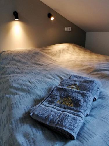 a bed with a towel sitting on top of it at Villa Alpina - 5 minut do szlaków i wyciągów in Szklarska Poręba