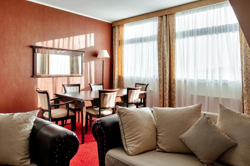 a living room with a couch and a table at Grand Royal Hotel in Poznań