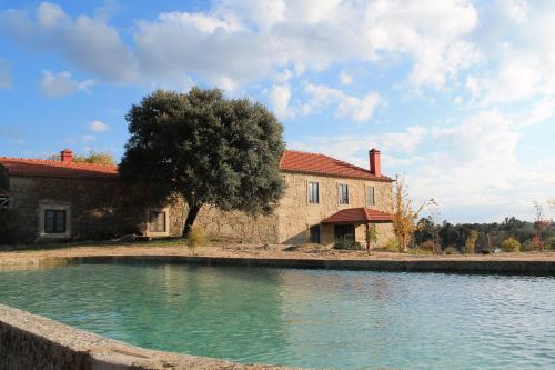 a house with a pool of water in front of a building at Quinta da Alma Cheia in Ninho do Açor