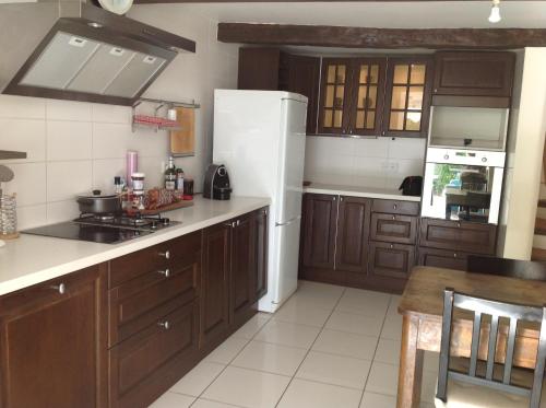 une cuisine avec des armoires en bois et un réfrigérateur blanc dans l'établissement La Maiouneta, à Entrevaux
