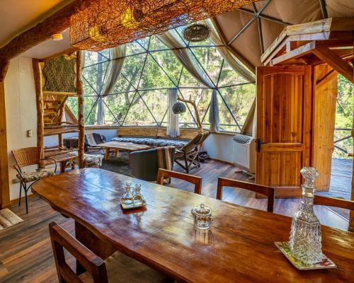 聖阿方索的住宿－Cascada de las Animas，一间带木桌和大窗户的用餐室
