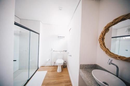 uma casa de banho com um WC e um espelho. em Pousada Morro do Farol em Fernando de Noronha