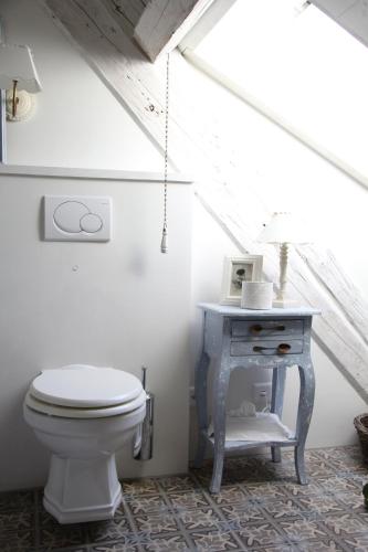 a bathroom with a toilet and a table at Bed and Breakfast Gantrisch Cottage Ferienzimmer in Rüeggisberg