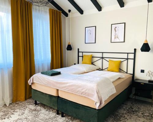 a bedroom with a large bed with yellow curtains at BESOTEL Erkrath- Ferienwohnungen und Apartments in Erkrath