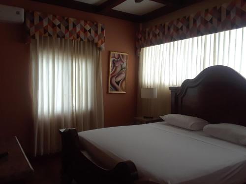 a bedroom with a bed with white sheets and windows at Spanish Dream Hotel in Kingston