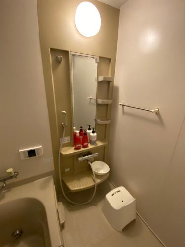 a bathroom with a sink and a toilet and a mirror at Maguro House in Osaka