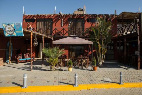an outdoor patio with tables and an umbrella at Sueños de Chicama in Puerto Chicama
